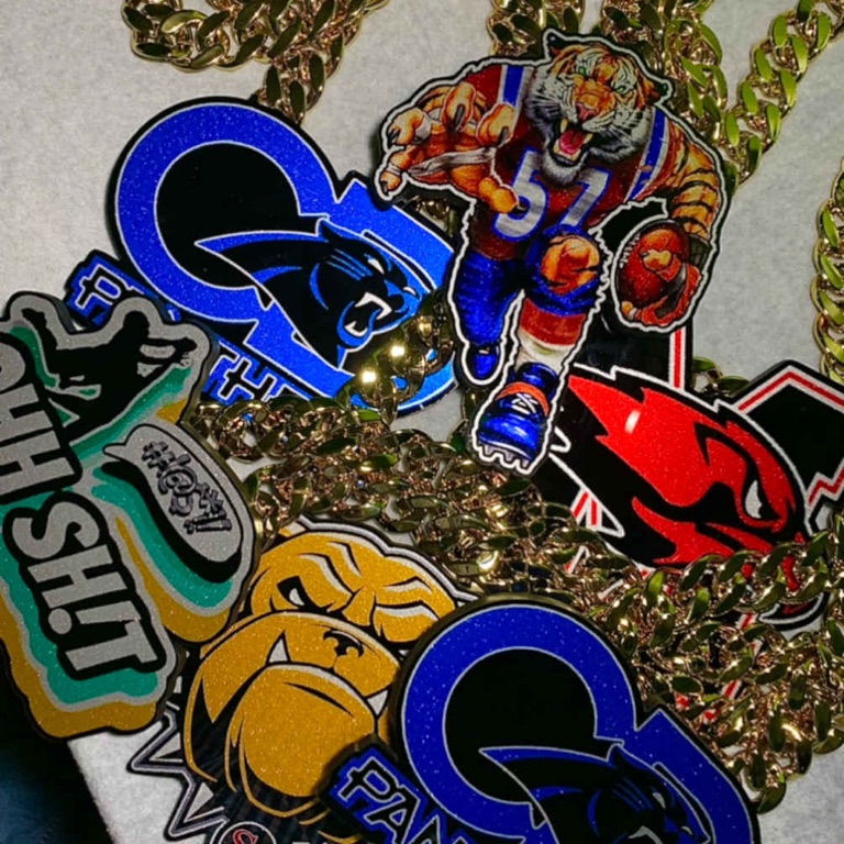Pile of custom team pendants and chains in mixed designs